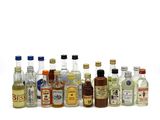 many bottles of alcohol lined up on a white surface