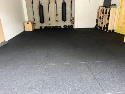 une photo d'une salle de sport avec un sol en carrelage noir