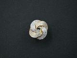 une bague en forme de nœud en or et diamants sur un fond noir