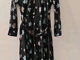 black floral print dress with long sleeves and a belt on a hanger