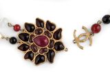 an image of a close up of a necklace with pearls and a flower