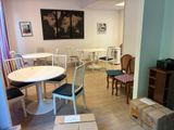 une pièce dans laquelle se trouvent une table, des chaises et une télévision