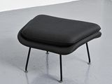 a black foot stool with a black cushion on it