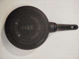 a black frying pan on a white surface
