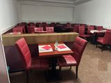 des tables et des chaises dans un restaurant aux sièges en cuir rouge et aux murs blancs