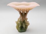 a small vase with a flower on it on a white surface