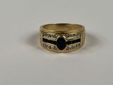 gros plan d'une bague en or avec une pierre noire
