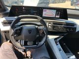 someone is sitting in the driver ' s seat of a car with their feet on the steering wheel