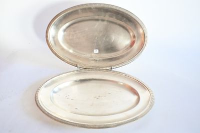 un plat en argent muni d'un couvercle en argent, posé sur une surface blanche