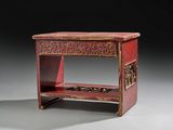 a small red table with a drawer on it
