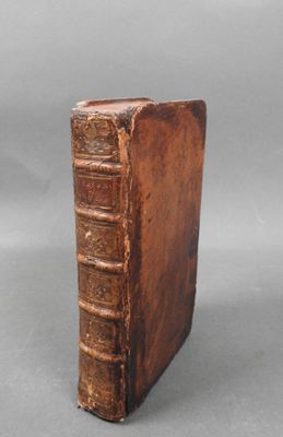 an old book sitting on top of a table next to a gray background