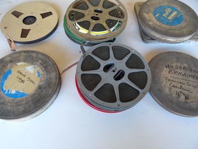plusieurs bobines de film posées sur une table blanche