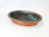 a small copper bowl on a white surface