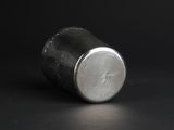 a close up of a silver cup on a black surface