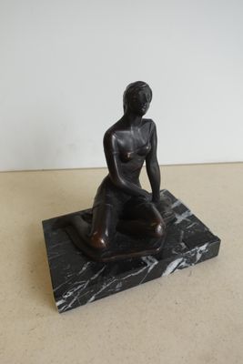 statue d'une femme assise sur un socle en marbre