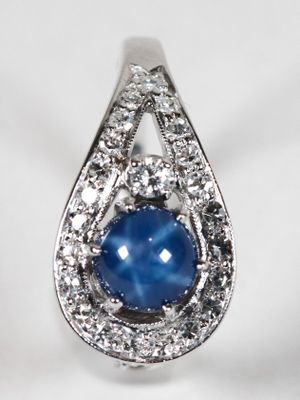 un gros plan sur une bague sertie d'un saphir étoilé bleu et de diamants
