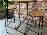 trois tabourets et une table devant un mur de briques