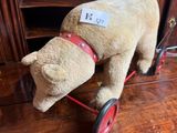 un ours en peluche assis sur une petite voiture