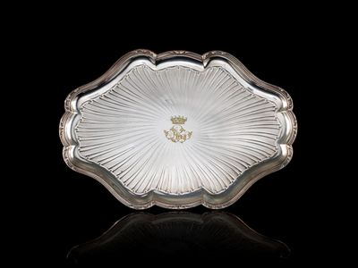 une assiette ancienne en argent plaqué, ornée d'un motif floral sur le bord