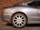 a silver car parked in front of a brick wall