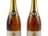 Deux bouteilles de champagne sont posées côte à côte sur une surface blanche.