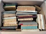 a box full of old books sitting on the floor