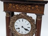 a clock that is sitting on a stand on a table