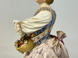 a figurine of a woman holding a basket of flowers