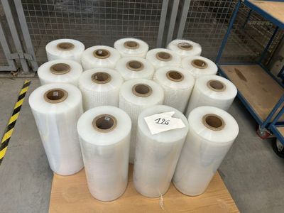 plusieurs rouleaux de film alimentaire transparent sur une palette dans un entrepôt