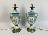 pair of blue and gold vases with flowers on them on a white background