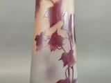a glass vase with purple leaves on it