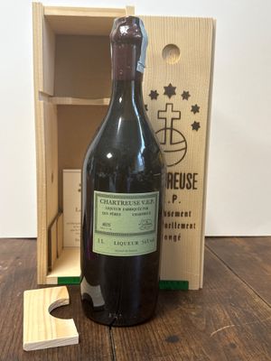 une bouteille de vin posée sur une table à côté d'une caisse en bois