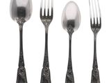 four forks and spoons are lined up on a white surface