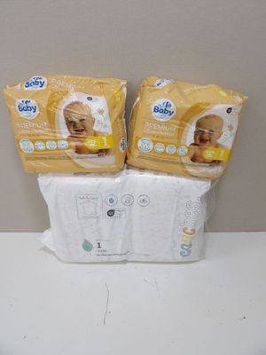 deux paquets de couches pour bébé posés sur un plan de travail blanc