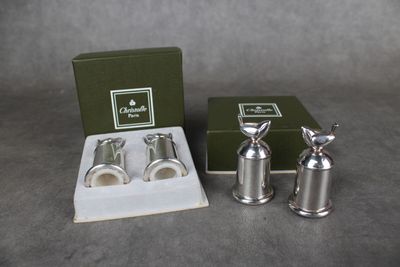 deux salières et poivrières en argent dans une boîte verte