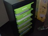 a man standing in front of a black and green filing cabinet