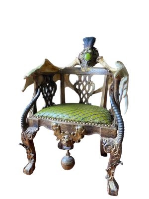 une chaise en bois avec une assise rembourrée verte sur laquelle est posé un oiseau