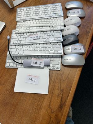 a computer keyboard and mouse on a desk with a notepad