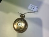 une montre de poche en or posée sur une table blanche