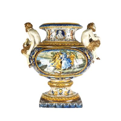 un grand vase avec un tableau posé sur une table
