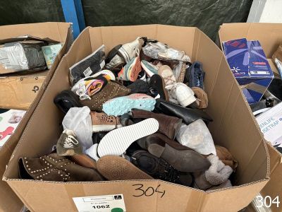 plusieurs paires de chaussures dans une boîte en carton posée sur le sol