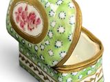 a green and white box with a pink flower on it