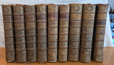 plusieurs vieux livres sont alignés sur une table en bois