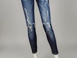 Une femme vêtue d'un haut blanc et d'un jean bleu se tient devant un mannequin.