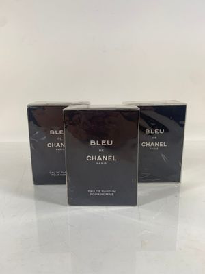 three chanel perfume bottles on a white surface with a white background