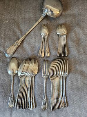 quatre cuillères en argent et une cuillère posée sur un repose-cuillère, sur une table