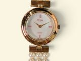 a close up of a wrist watch with pearls on it