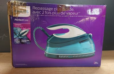 la boîte d'un fer à repasser à vapeur bleu et blanc posée sur une table en bois