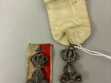 une vieille médaille avec un ruban et deux autres objets posés sur une table