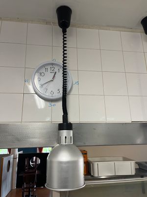 une horloge accrochée au mur au-dessus d'un évier dans une cuisine